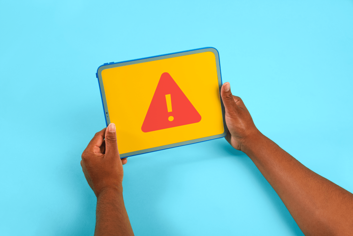 What is Incident Management - Hands holding iPad with a red warning sign.