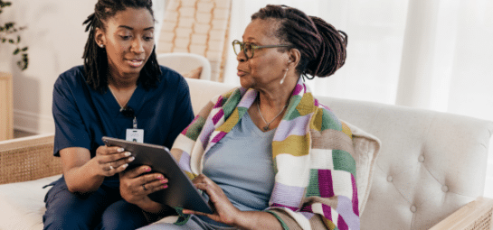 zorgmedewerker en client op de bank met een tablet